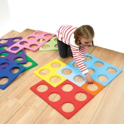 child playing with large numicon foam shapes