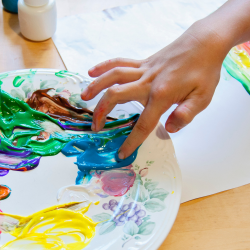 child dipping finger into paint