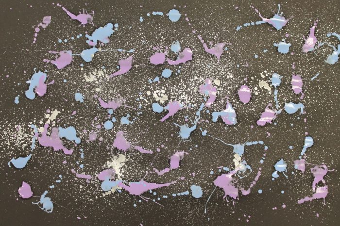 blue and purple paint splatters on black paper