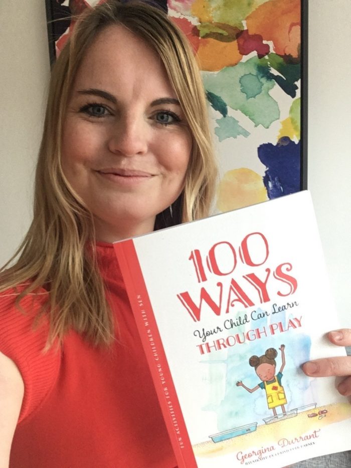 Woman holding book with 100 fun activities for children 