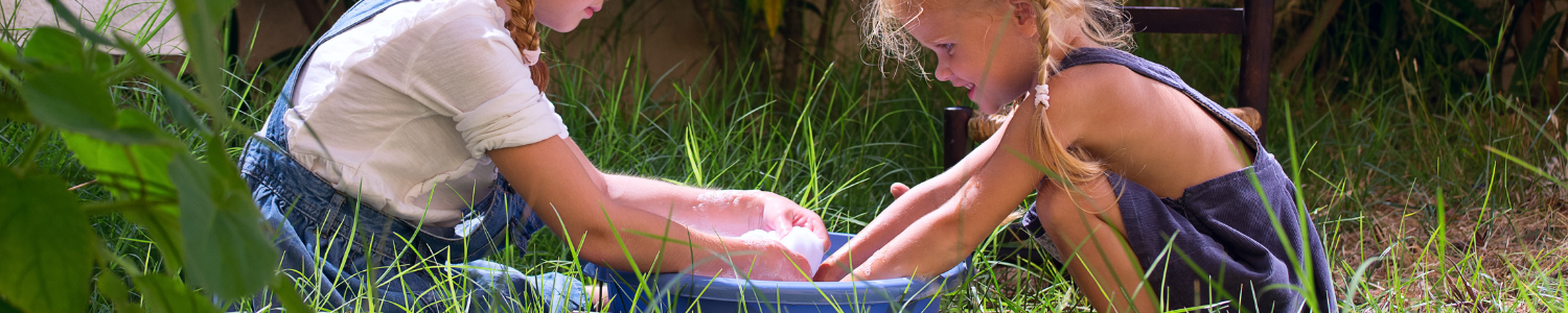 two children playing with tub of water