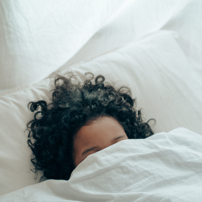 child resting under covers