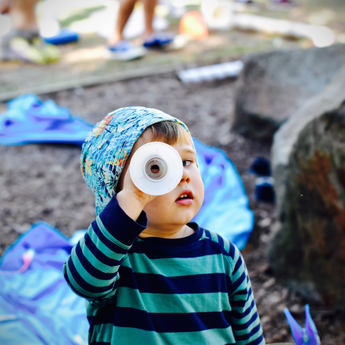 child looking through a tube