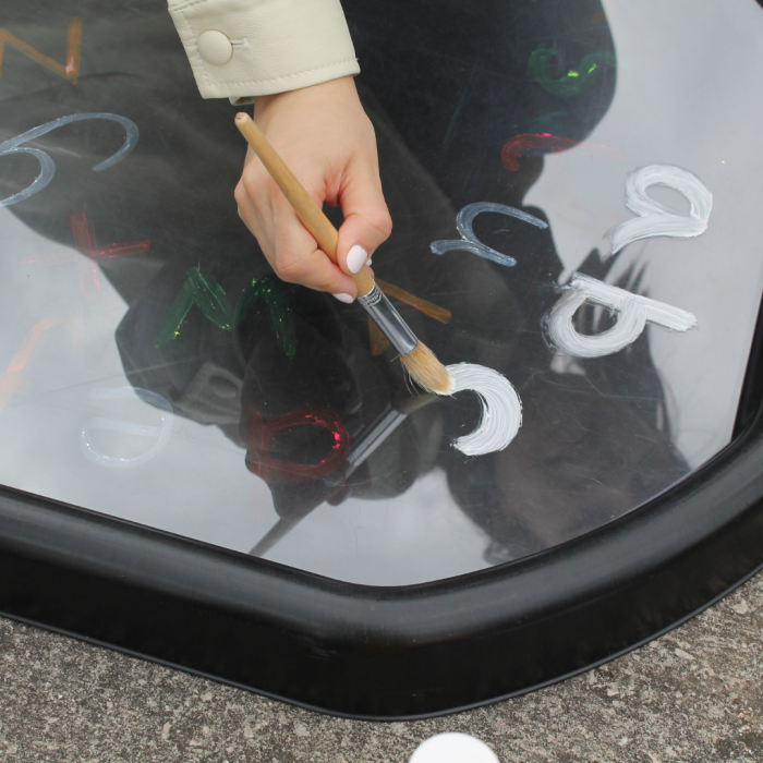 tracing letters in paint on an acrylic mat